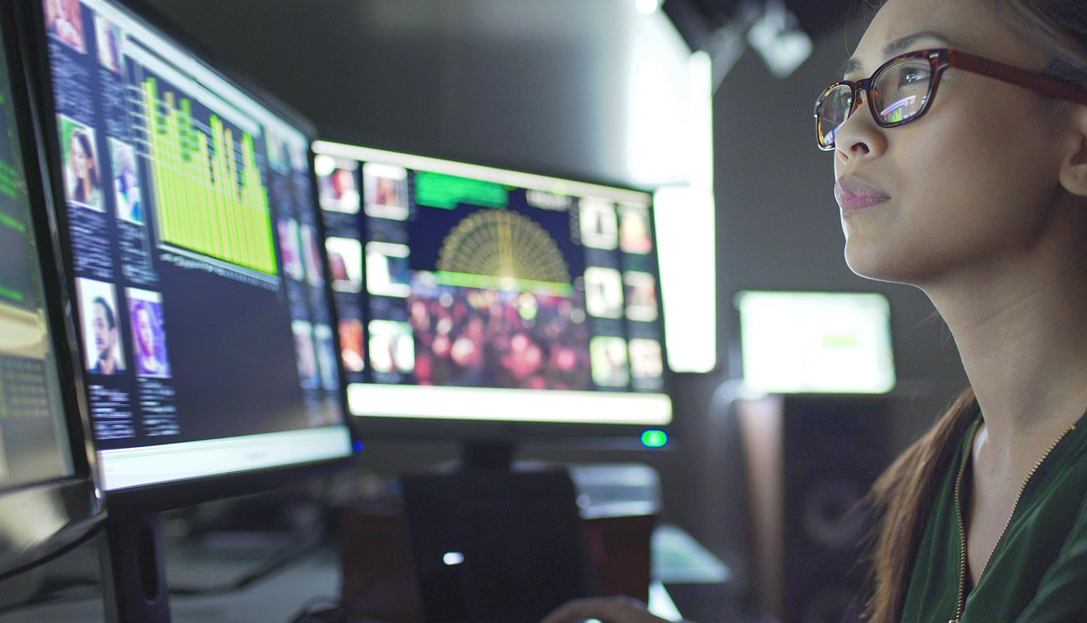 A person is focused on multiple computer screens displaying various content platforms and analytics tools, analyzing data related to AI models, content strategy, and SEO rankings. The setup highlights the use of AI systems for creating citation-worthy content and tracking brand visibility across digital platforms.