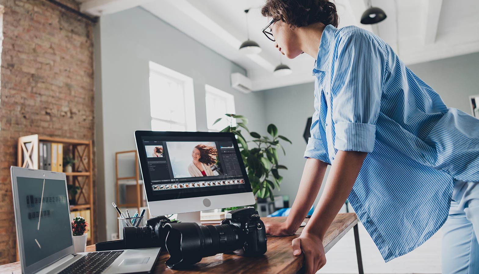 A professional photographer is focused on editing product images on a computer, with editing software clearly displayed on the screen, showcasing the design process and the use of AI tools for enhancing image quality. The scene highlights the importance of creative control and efficient workflows in web design and content creation.