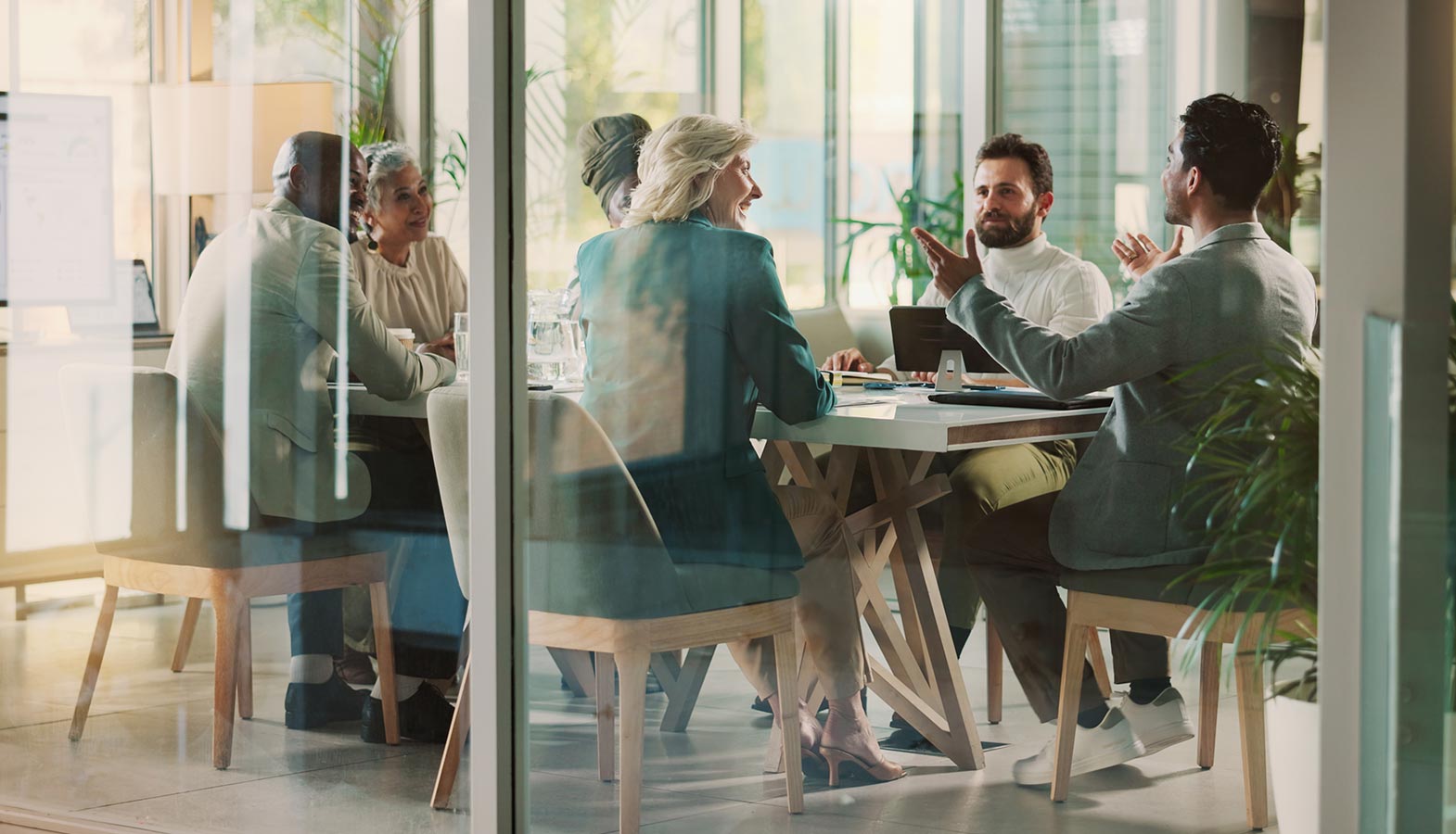 A group of business professionals is engaged in a discussion about digital strategy around a modern conference table, highlighting their collaboration on web design and development solutions. This meeting reflects the importance of effective digital marketing and the role of web design agencies in driving business growth.